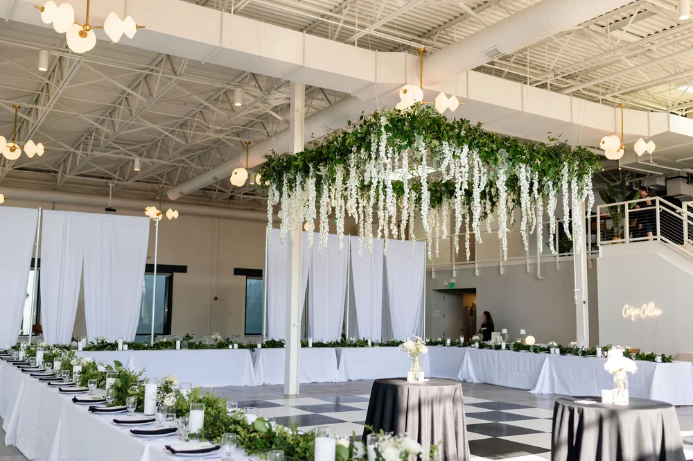 Wedding reception with hanging greenery and black and white dance floor at PINE venue in Charlotte NC