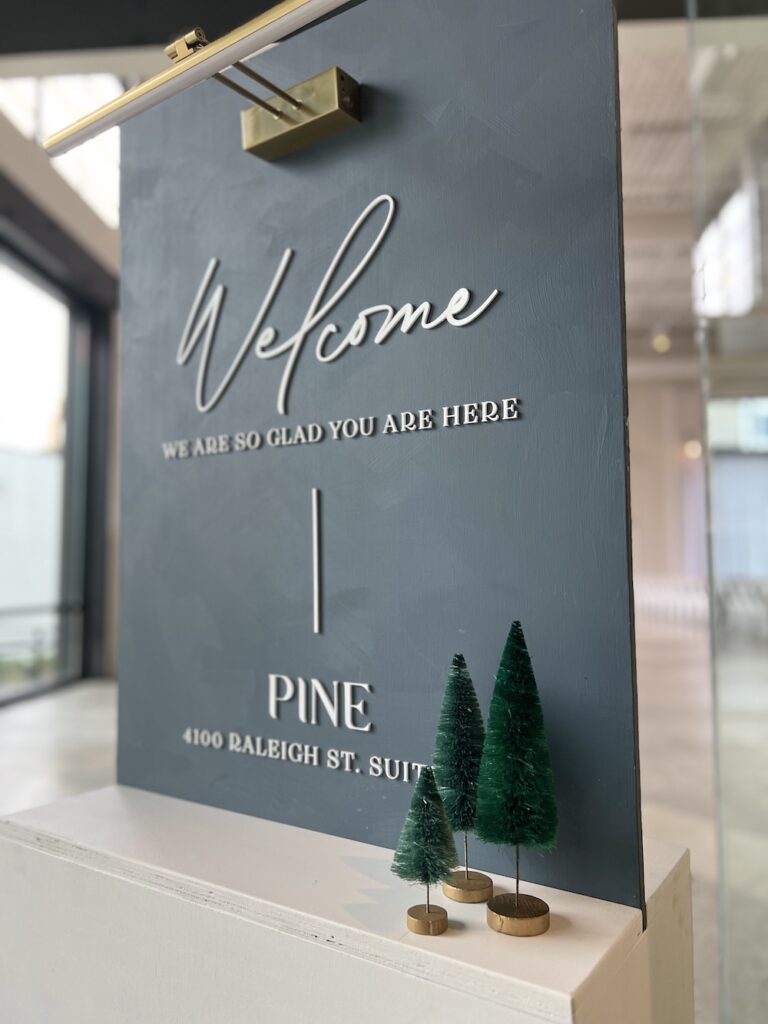 Welcome sign with holiday decor at PINE