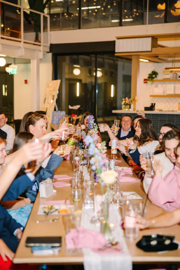Guests cheers-ing at a wedding at PINE in Charlotte, NC