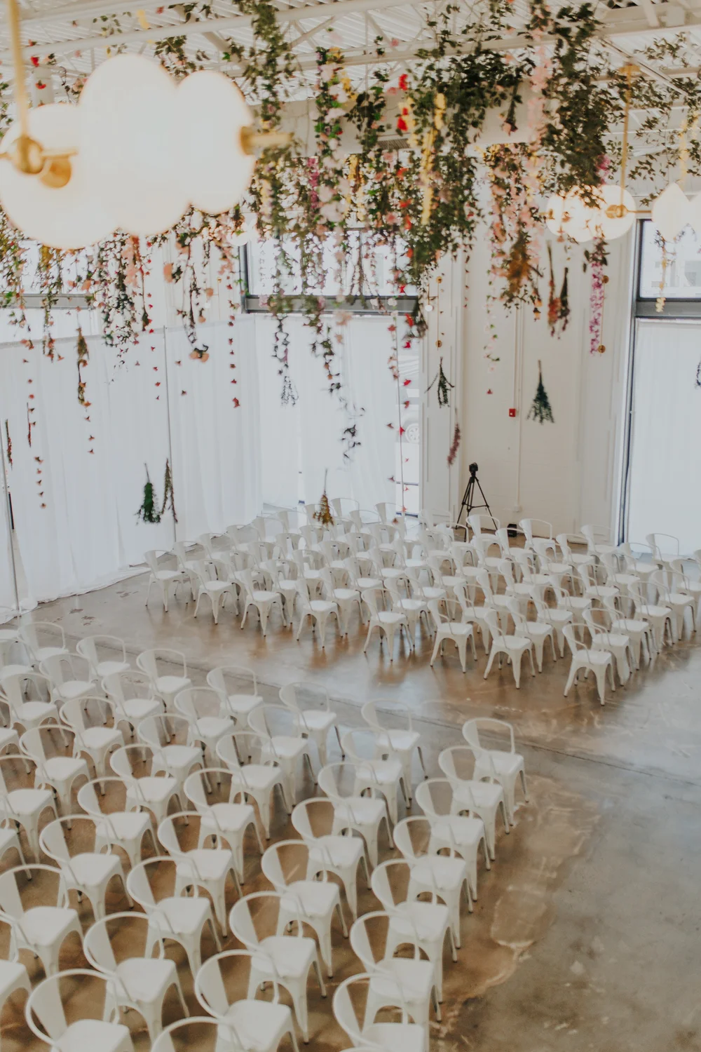 Wedding ceremony with a large floral installation suspended from the ceiling at PINE in Charlotte