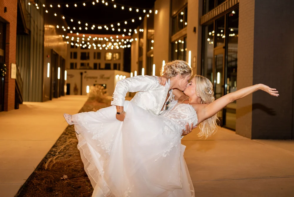LGBTQ+ brides kissing outside of PINE in Charlotte NC